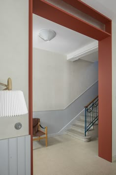 an open door leading to a room with white walls and red trim on the wall