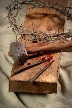 the crown of jesus is on top of a piece of wood with nails and knives