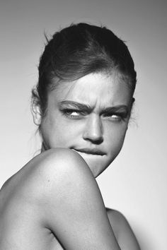 a black and white photo of a woman's face with her hands on her chest