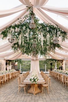 the inside of a tent with tables and chairs set up for an outdoor wedding reception