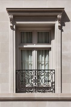 an iron balcony railing and window on a building