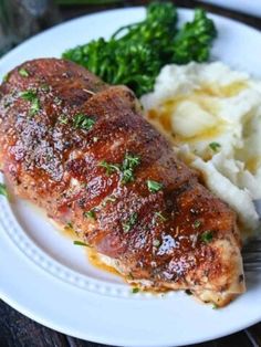 a white plate topped with meat and mashed potatoes