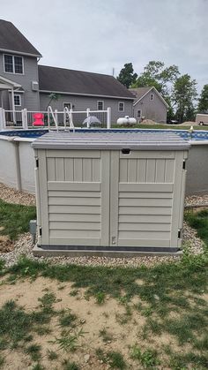 an above ground swimming pool in the middle of a yard with grass and gravel around it