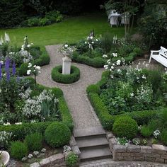 an outdoor garden with stone steps and flowers in the center, surrounded by greenery