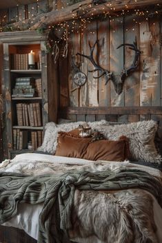 a rustic bedroom decorated with deer heads and lights on the headboard, bed linens and pillows