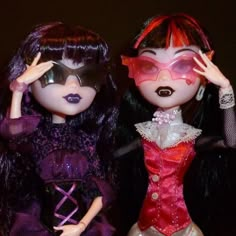 two dolls are posed next to each other