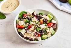 a salad in a bowl with dressing on the side