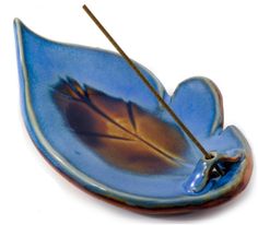 a blue leaf shaped object with a twig sticking out of it's center