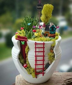 a planter that has plants in it and a red ladder going up the side