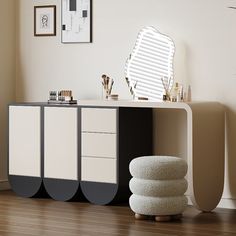 a white and black sideboard sitting on top of a wooden floor next to a window