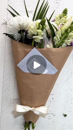 a bouquet of flowers is wrapped in brown paper