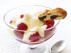 a glass bowl filled with ice cream and strawberries