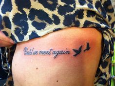 a woman with a tattoo on her stomach that says alive we meet again, and a bird