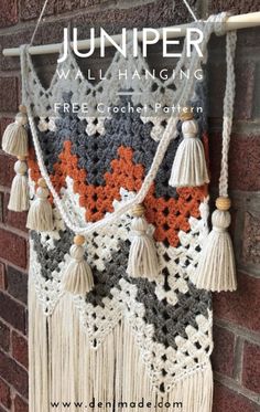 a crocheted wall hanging with tassels on it