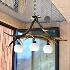 the antler chandelier has three lights hanging from it