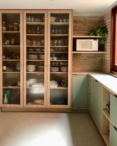 a kitchen filled with lots of cupboards and dishes on top of it's shelves