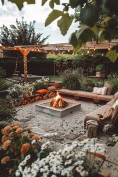 an outdoor fire pit surrounded by flowers and patio furniture with string lights strung over it