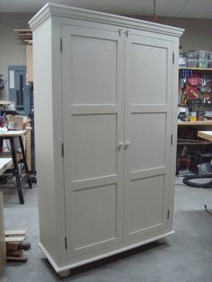 a tall white cabinet sitting in a garage