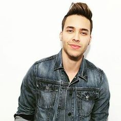 a young man in a denim jacket posing for the camera