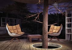 two chairs sitting on top of a wooden floor next to a tree