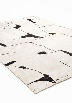 an area rug with black and white designs on the top, in front of a white background