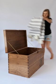 a woman is walking past a wooden box