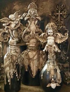 antique vases and statues are displayed on a shelf in front of an ornate mirror