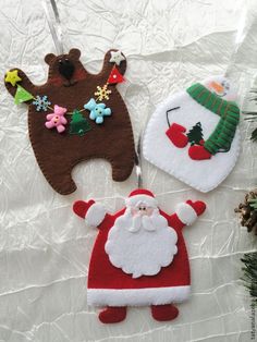 two christmas ornaments hanging on a white sheet