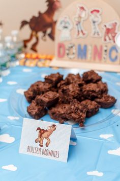 chocolate brownies are on a blue table cloth with a sign that says, bullste brownies