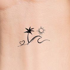 a small palm tree tattoo on the back of a woman's left side shoulder