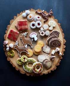 a wooden plate topped with lots of different types of cookies and pastries on top of it