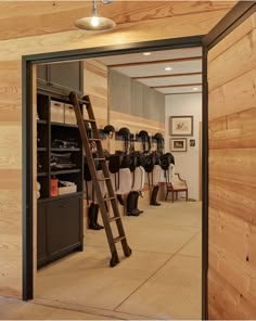 the inside of a horse stable with wooden walls and ladder leading up to it's stalls