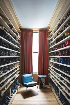 a room with many pairs of shoes on the shelves and a chair in the corner