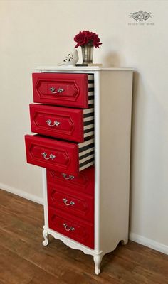 a red and white dresser with three drawers