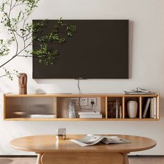 a living room with a table, television and bookshelves on the wall above it