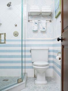 a white toilet sitting next to a walk in shower