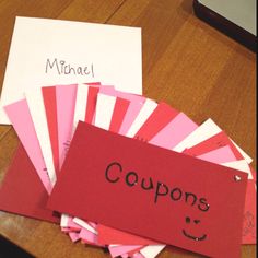 a pile of coupons sitting on top of a table next to a red sign