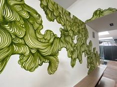 the wall is decorated with green swirls on it's sides and has a bench in front of it