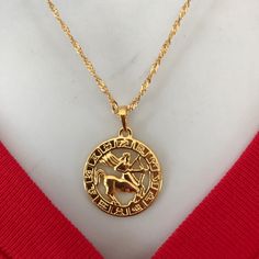 a gold necklace with an image of a horse and rider on the front is shown