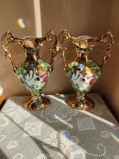 two golden vases sitting on top of a table