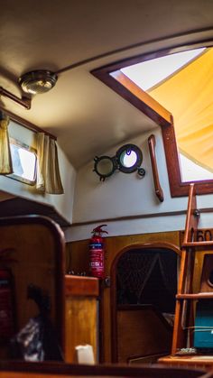 the inside of a boat with wooden ladders, windows and other items on display