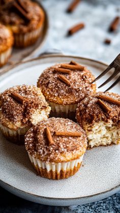 a plate topped with cupcakes covered in powdered sugar and pecans next to a fork