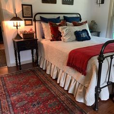 a bedroom with a bed, rug and pictures on the wall