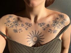 a woman with sun and flowers on her chest