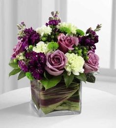 a vase filled with purple and white flowers