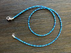 This beaded necklace is made with different shades of blue Toho seed beads. Each necklace will be unique in that the beads will be chosen randomly. Blue Heishi Bead Necklaces, Handmade Blue Beaded Necklaces With Oval Beads, Blue Heishi Beads Necklace, Blue Heishi Beads Necklace With Round Beads, Blue Beaded Necklace With Colorful Oval Beads, Blue Beaded Necklace With Multicolored Oval Beads, Handmade Blue Beaded Necklace With Oval Beads, Blue Heishi Beads Bracelet With Tiny Beads, Blue Heishi Beads Necklace With Colorful Beads