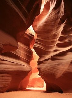 a narrow slot in the side of a canyon with light coming from it's windows