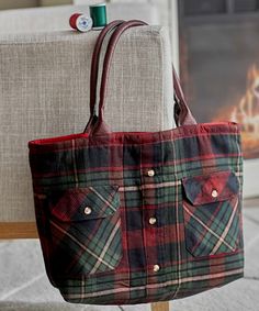 a red and green plaid purse sitting on top of a chair