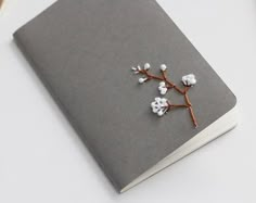 a gray notebook with cotton flowers on it