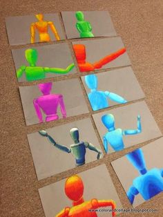 paper cut out of different colored figures sitting on the floor